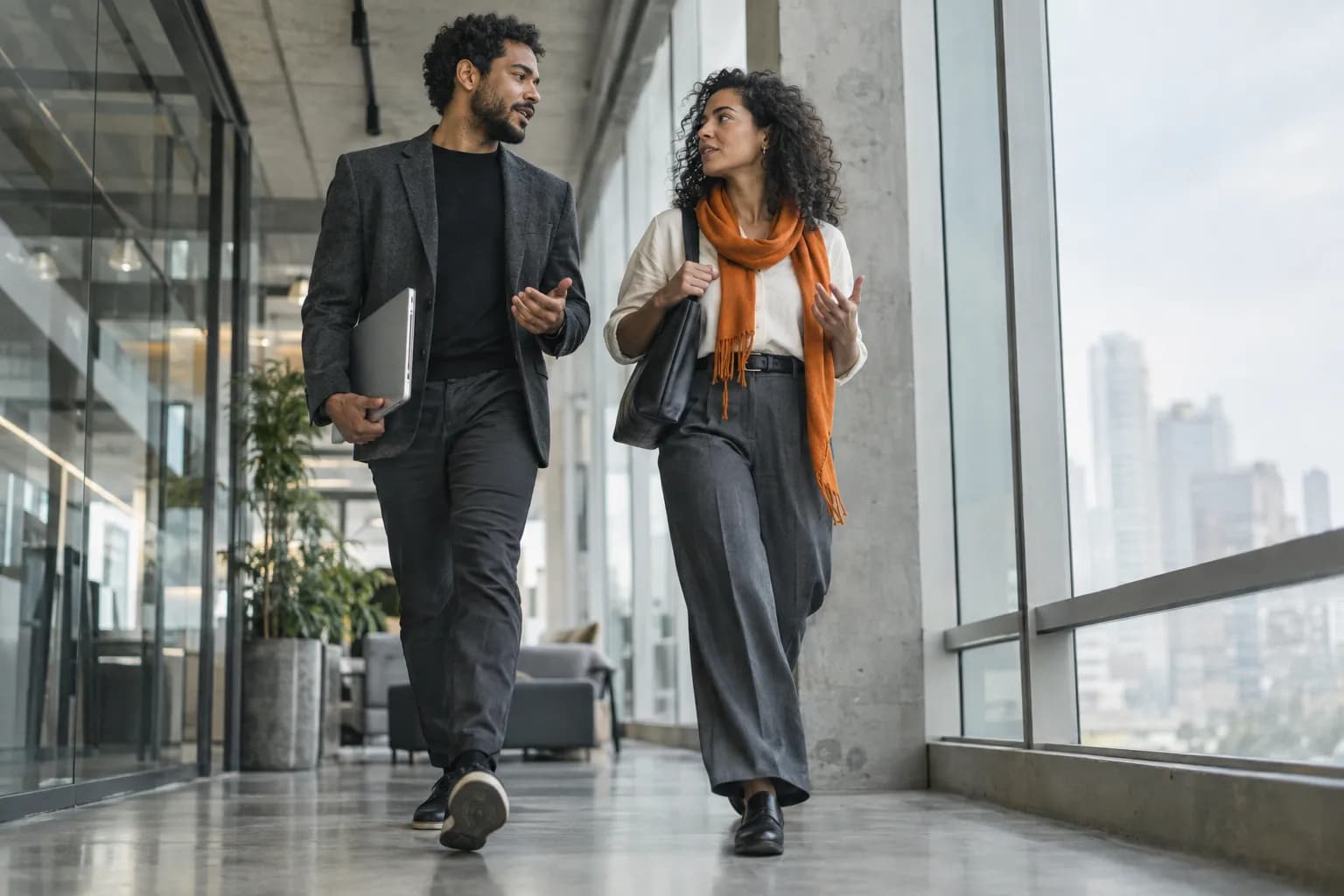 Duas pessoas conversando enquanto caminham pelo corredor do escritório